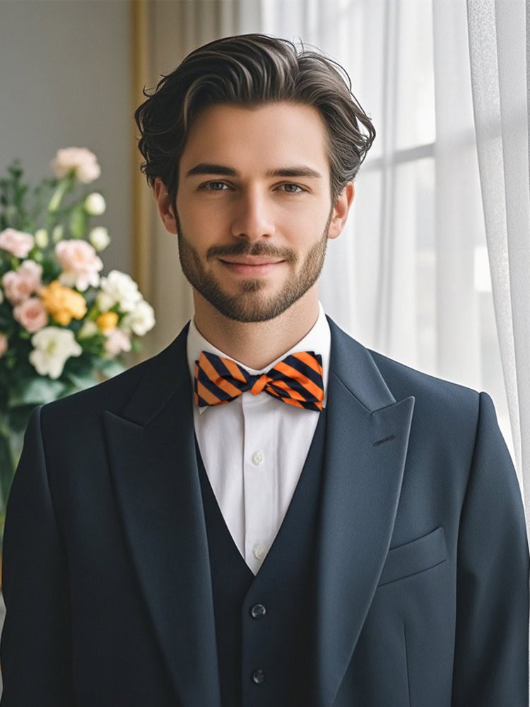 A model wearing a dark suit and a navy - orange self - tied bow tie.