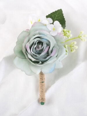 Ombre blue rose boutonniere with white small flowers and a green leaf