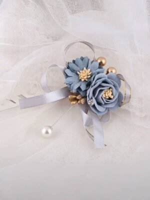 Light blue floral brooch with gold accents, gray ribbons and a pearl