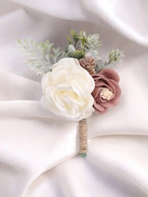 Rustic - style mixed floral boutonniere with white and brown flowers, green foliage and a pine cone
