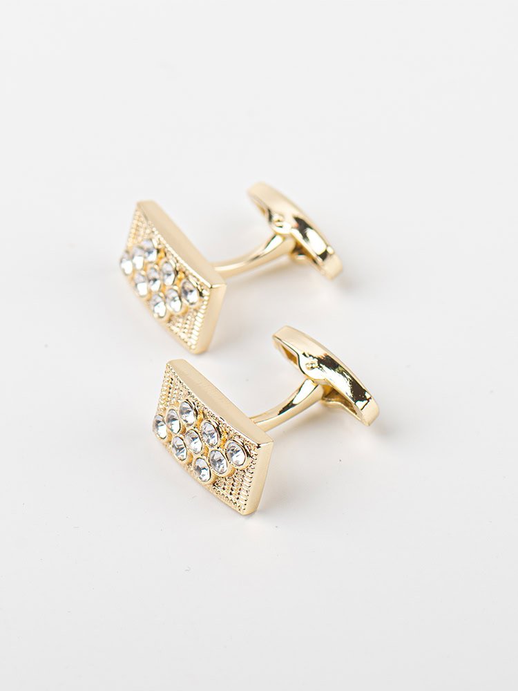 A pair of golden - toned rectangular cufflinks encrusted with diamonds.