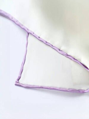 Close - up of an iris - colored border on a white silk pocket square.