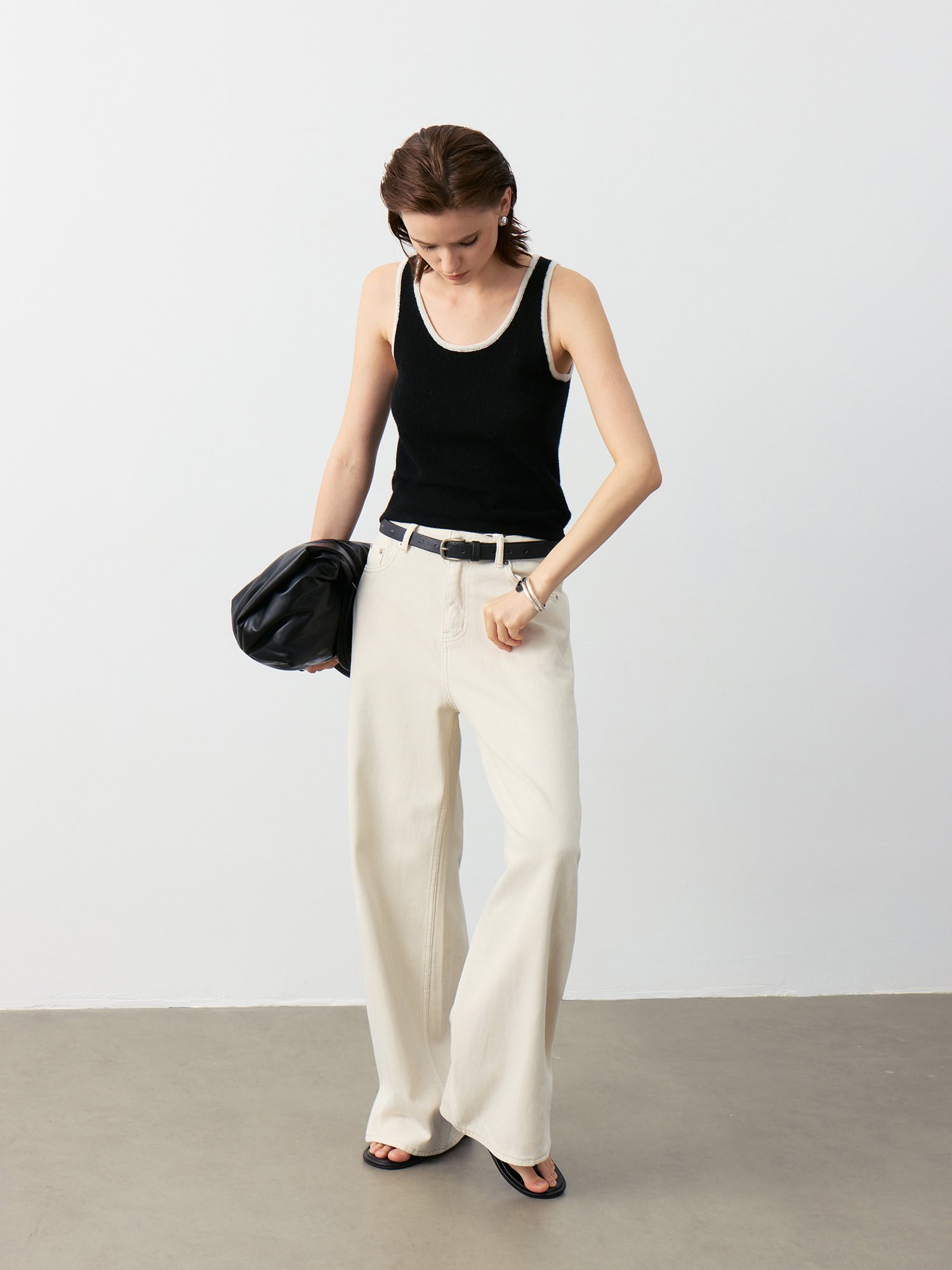 Luxury Rebel Cashmere Tank Top Outfit | Black with Contrast Trim (Ivory/Black) Paired with Ivory Wide-Leg Jeans & Black Bag - Edgy Luxury