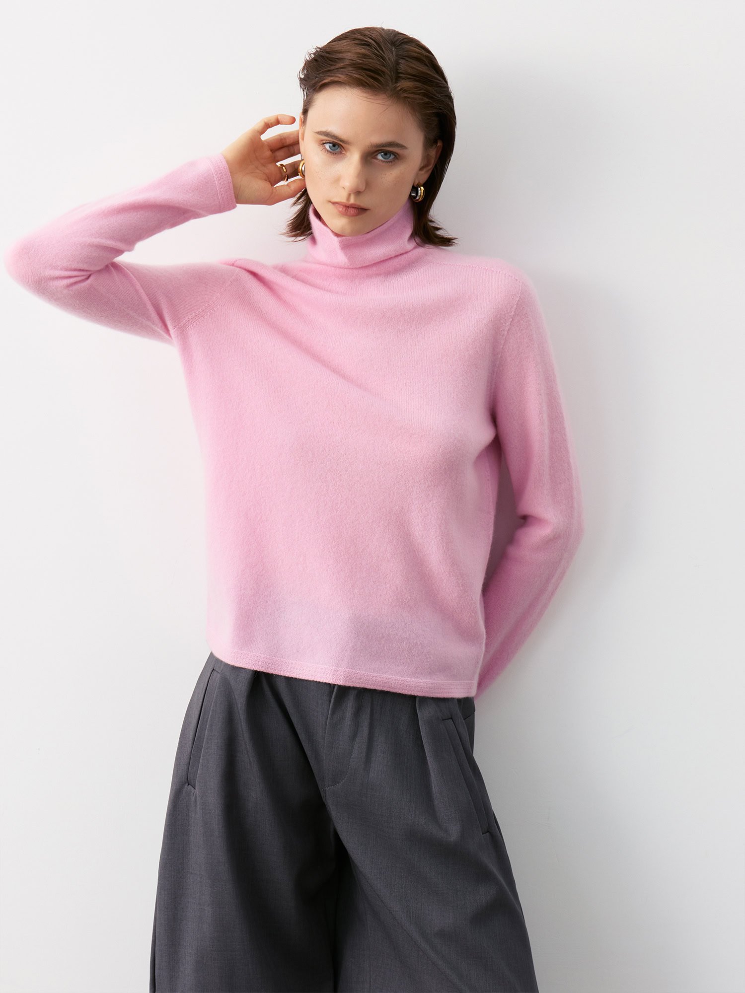 Model Wearing Blush Pink 100% Cashmere Slim-Fit Turtleneck Sweater with Charcoal Grey Wide-Leg Pants, Side View