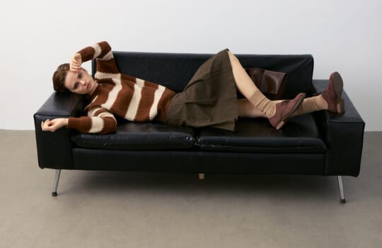 Striped Cashmere Sweater Model on Black Leather Sofa - Polished Casual Style