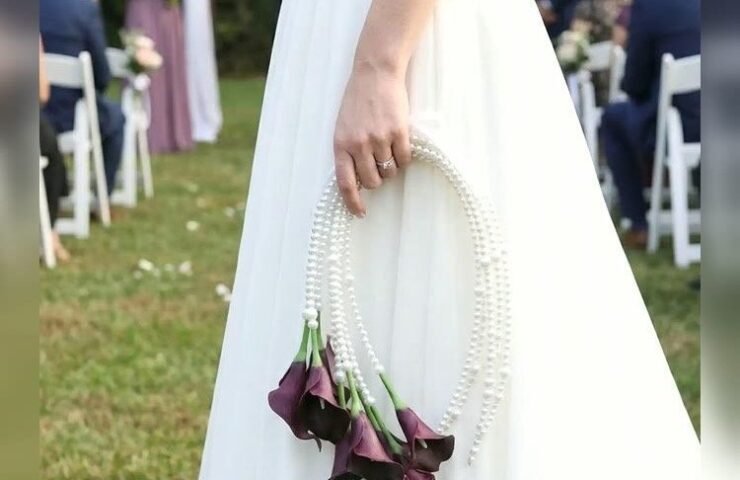 Bride carrying a purple calla lily pearl bridal bouquet at a wedding