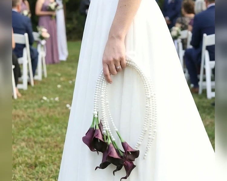 Bride carrying a purple calla lily pearl bridal bouquet at a wedding